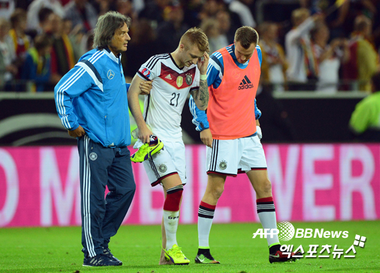 독일 축구대표팀의 미드필더 마르코 로이스가 스코틀랜드와의 유로2016 예선 도중 발목을 다쳐 동료의 부축을 받으며 경기장을 빠져 나가고 있다. ⓒAFPBBNews=News1