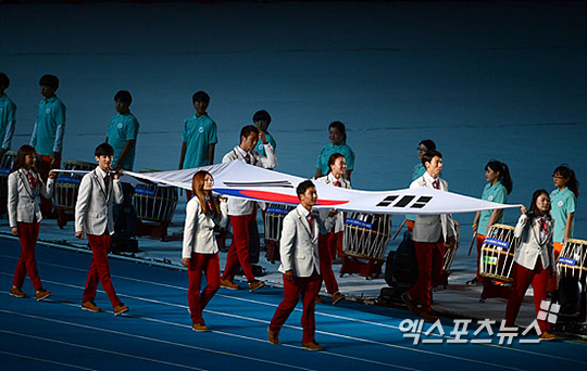2014 인천아시안게임에서 메달을 획득한 한국 선수 8명이 대형 태극기를 들고 폐회식에 입장하고 있다 ⓒ 엑스포츠뉴스 권태완 기자 