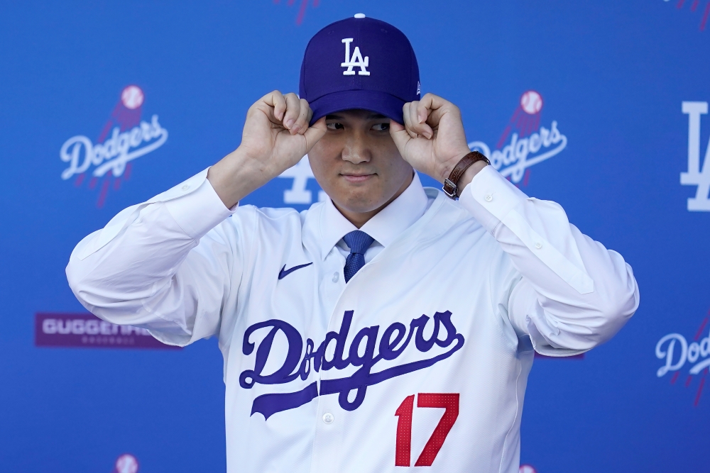 오타니 쇼헤이가 미국 캘리포니아주 로스앤젤레스 다저스타디움에서 열린 미국프로야구 LA 다저스 입단 기자회견에서 모자를 쓰고 있다. AP/연합뉴스.