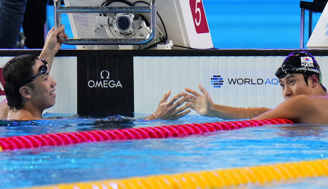 황선우(오른쪽)가 12일 카타르 도하 어스파이어돔에서 열린 2024 세계수영선수권대회 남자 자유형 200m 예선을 무난히 통과한 뒤 같이 경쟁한 일본 대표 마쓰모토 가쓰히로와 악수하고 있다. 황선우는 준결승에 진출했다. 