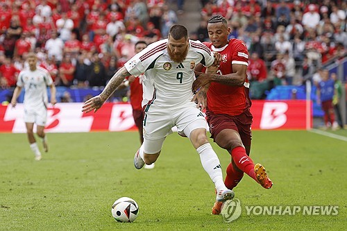 프랑스 언론 르퀴프가 16일(한국시간) 헝가리 축구 국가대표팀으로 유럽축구연맹(UEFA) 유로 2024 데뷔전을 치른 마틴 아담을 집중 조명했다.   마틴은 이날 독일 쾰른 스타디움에서 열린 스위스와의 대회 A조 1차전에 후반 교체 출전해 11분간 활약하며 유로 데뷔전을 치렀다.   팀은 1-3으로 패했지만, 아담은 이번 대회 최고의 스타로 발돋움했다. 그는 후반 34분 수비수 밀로스 케르케즈를 대신해 공격수로 출전했다. 연합뉴스