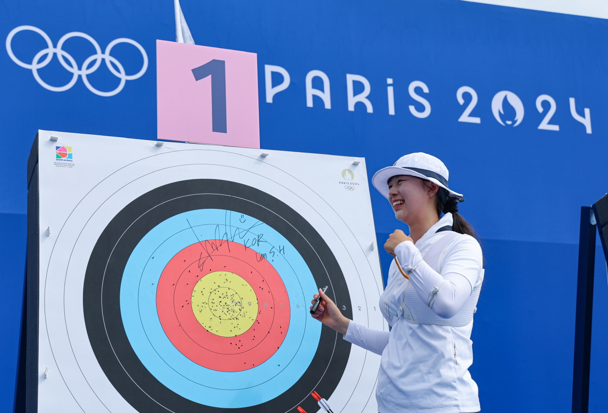 여자 양궁 국가대표 임시현이 25일(한국시간) 프랑스 파리 레쟁발리드에서 열린 2024 파리 올림픽 여자 양궁 랭킹 라운드에 출전해 총점 694점으로 세계신기록을 수립하며 전체 64명의 선수 중 1위를 차지한 뒤 과녁 앞에서 웃고 있다. 임시현은 지난해 항저우 아시안게임에서 3관왕에 오르며 한국 여자 양궁 새 여제로 올라선 간판 궁사다. 사진 연합뉴스