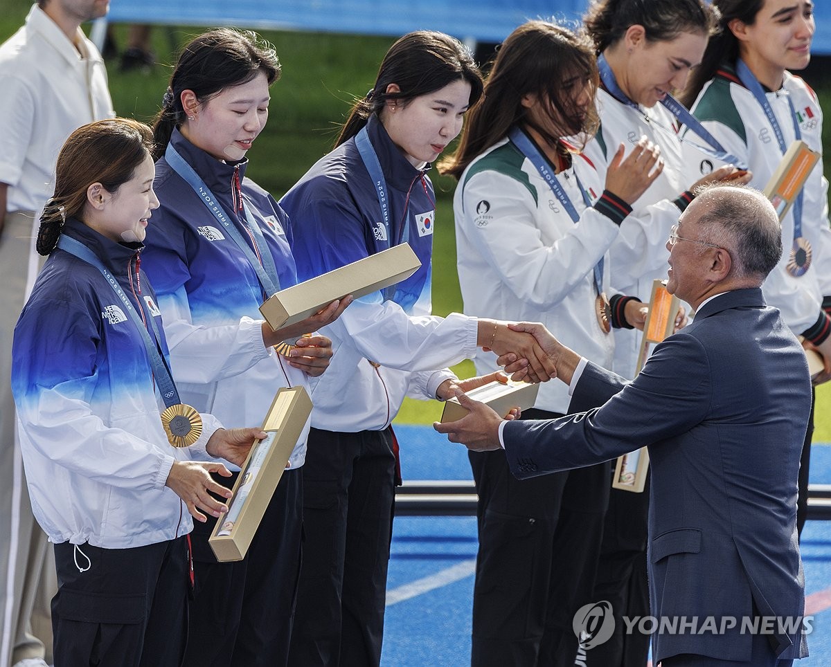 (파리=연합뉴스) 황광모 기자 = 28일(현지시간) 프랑스 파리 레쟁발리드에 양궁 경기장에서 열린 2024 파리올림픽 양궁 여자단체전에서 올림픽 연속 10연패를 달성한 남수현(오른쪽)이 정의선 현대차 회장에게 금메달 부상을 전달받고 있다. 2024.7.29 hkmpooh@yna.co.kr