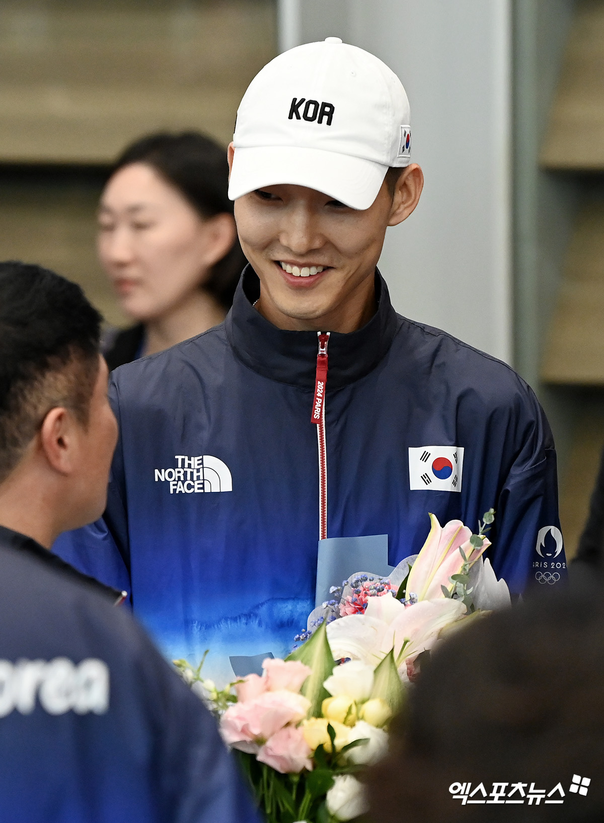 남자 육상 높이뛰기 간판 스타 우상혁이 13일 인천국제공항을 통해 대한민국 본진 선수단 귀국 때 함께 입국장에 들어선 뒤 꽃다발을 받고 있다. 우상혁은 한국 육상 트랙 앤드 필드 첫 올림픽 메달을 노렸으나 아쉽게 7위를 기록했다. 인천공항, 고아라 기자