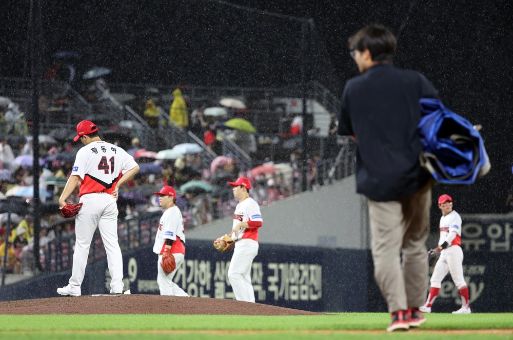 20일 광주기아챔피언스필드에서 열린 프로야구 롯데 자이언츠와 KIA 타이거즈의 경기. KIA가 3-1로 앞선 4회초 수비 때 갑자기 쏟아지는 뇌우로 경기가 중단돼 선발투수 황동하(왼쪽)가 아쉬워하고 있다. 연합뉴스