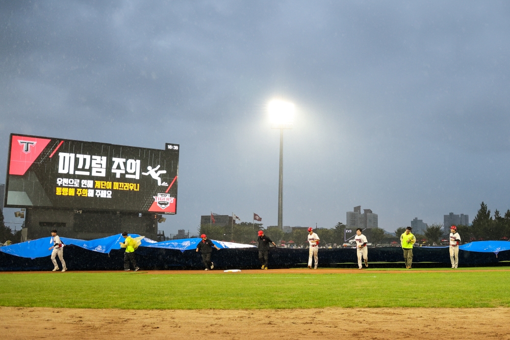 6일 광주-KIA챔피언스필드에서 열린 '2024 신한 SOL Bank KBO리그' 키움 히어로즈와 KIA 타이거즈의 경기, 1회초 2사 1루 경기가 우천으로 중단된 이후 대형 방수포가 설치되고 있다. KIA 타이거즈 제공