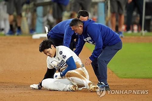 LA 다저스 오타니 쇼헤이가 27일 미국 캘리포니아주 로스앤젤레스의 다저스타디움에서 열린 2024 미국 메이저리그 월드시리즈 2차전 뉴욕 양키스와의 홈경기에서 도루 후 왼쪽 어깨에 통증을 호소하고 있다. 왼쪽 어깨 아탈구가 생긴 것으로 알려졌다. 다저스는 그럼에도 선발 야마모토 요시노부의 6⅓이닝 1실점 쾌투를 앞세워 양키스를 4-2로 제압했다. 전날 끝내기 만루홈런으로 챙긴 첫 승에 이어 월드시리즈 2연승을 내달렸다. 다저스와 양키스는 장소를 뉴욕으로 옮겨 29일부터 31일까지 3~5차전을 치를 예정이다. REUTERS/연합뉴스