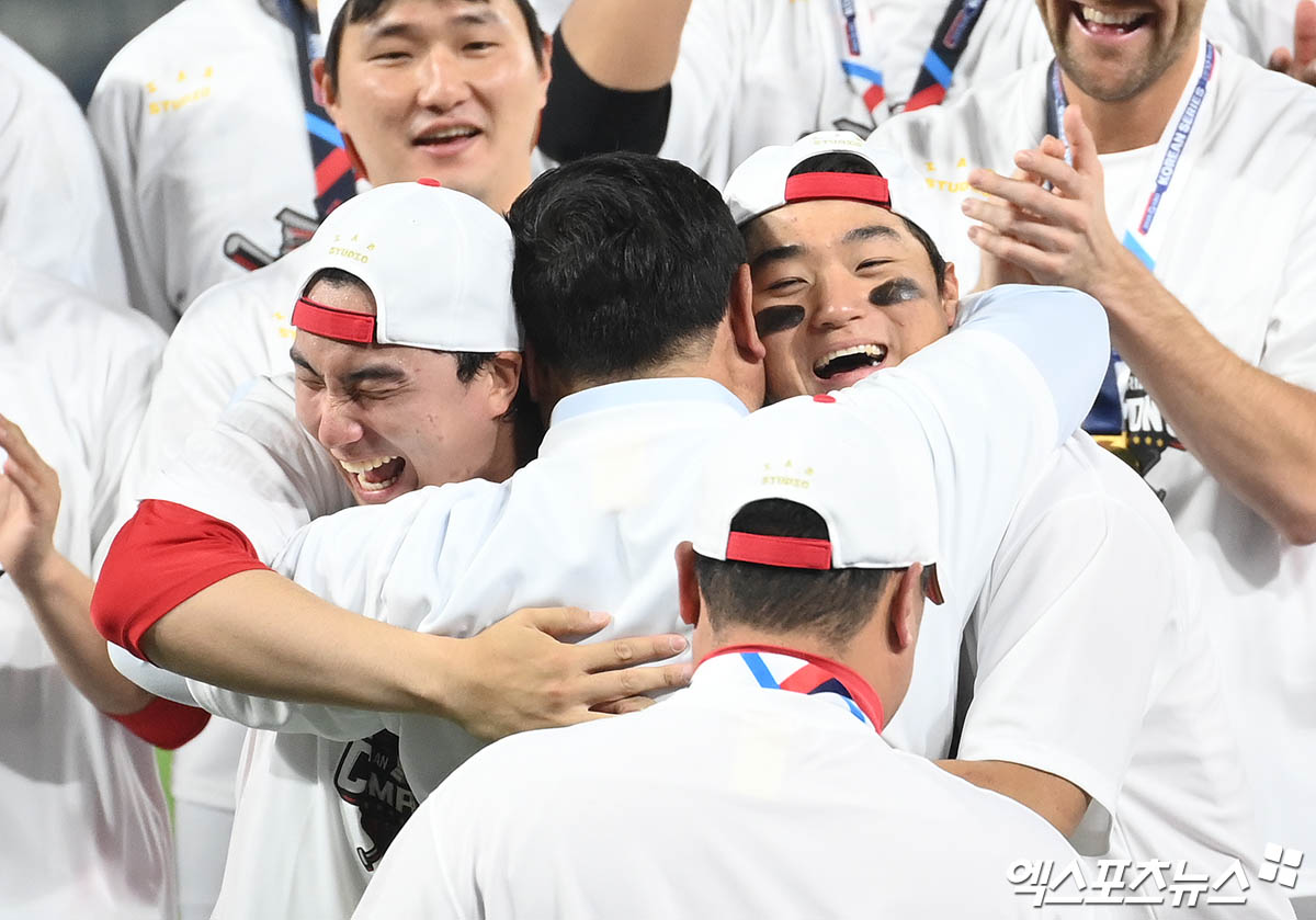 28일 오후 광주기아챔피언스필드에서 열린 '2024 신한 SOL Bank KBO 한국시리즈' 삼성 라이온즈와 KIA 타이거즈의 5차전 경기, KIA가 7:5의 스코어로 승리하며 7년 만에 통합 우승을 이뤄냈다.  경기 종료 후 KIA 심재학 단장이 정해영과 김도영을 끌어안고 있다. 광주, 김한준 박지영 기자