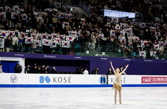 김채연이 23일 서울 목동 아이스링크에서 열린 2025 국제빙상경기연맹(ISU) 피겨스케이팅 사대륙선수권대회 여자 싱글 프리스케이팅 연기를 마친 뒤 태극기를 든 홈 관중 앞에서 인사하고 있다. 연합뉴스
