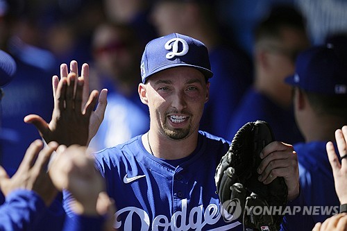 LA 다저스 블레이크 스넬이 메이저리그 시범경기에서 투구 후 더그아웃으로 들어와 동료들과 하이파이브하고 있다. AP/연합뉴스
