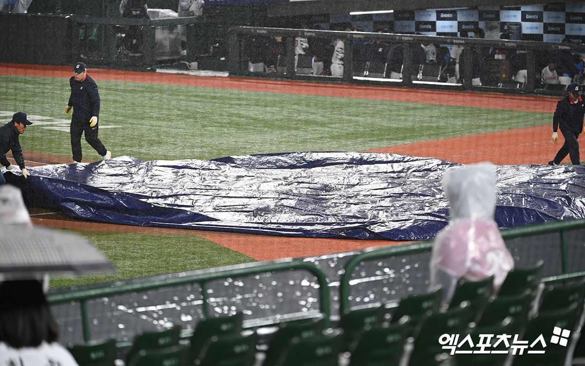 23일 오후 부산 동래구 사직야구장 열린 '2024 신한 SOL Bank KBO리그' SSG 랜더스와 롯데 자이언츠의 경기, 5회초 우천으로 인해 경기가 중단된 뒤 그라운드에 방수포가 뎦여지고 있다. 엑스포츠뉴스 DB