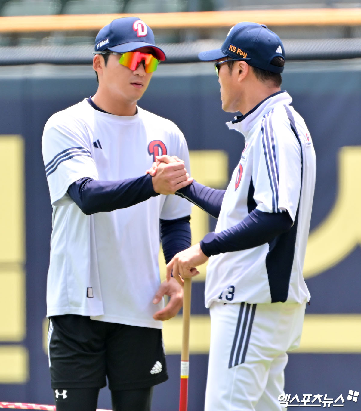 두산 베어스 외야수 김대한과 조성환 감독대행이 정규시즌 경기를 앞두고 대화하며 손을 맞잡고 있다. 엑스포츠뉴스 DB