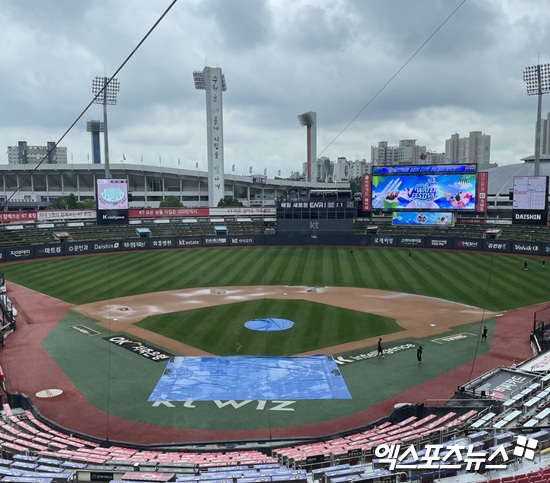 LG 트윈스와 KT 위즈는 14일 수원 KT위즈파크에서 2025 신한 SOL 뱅크 KBO리그 팀 간 12차전을 치른다. KT위즈파크엔 전날부터 쏟아진 비로 인해 방수포가 깔려 있다. 내야 곳곳에 물웅덩이도 보인다. 엑스포츠뉴스 수원, 김유민 기자