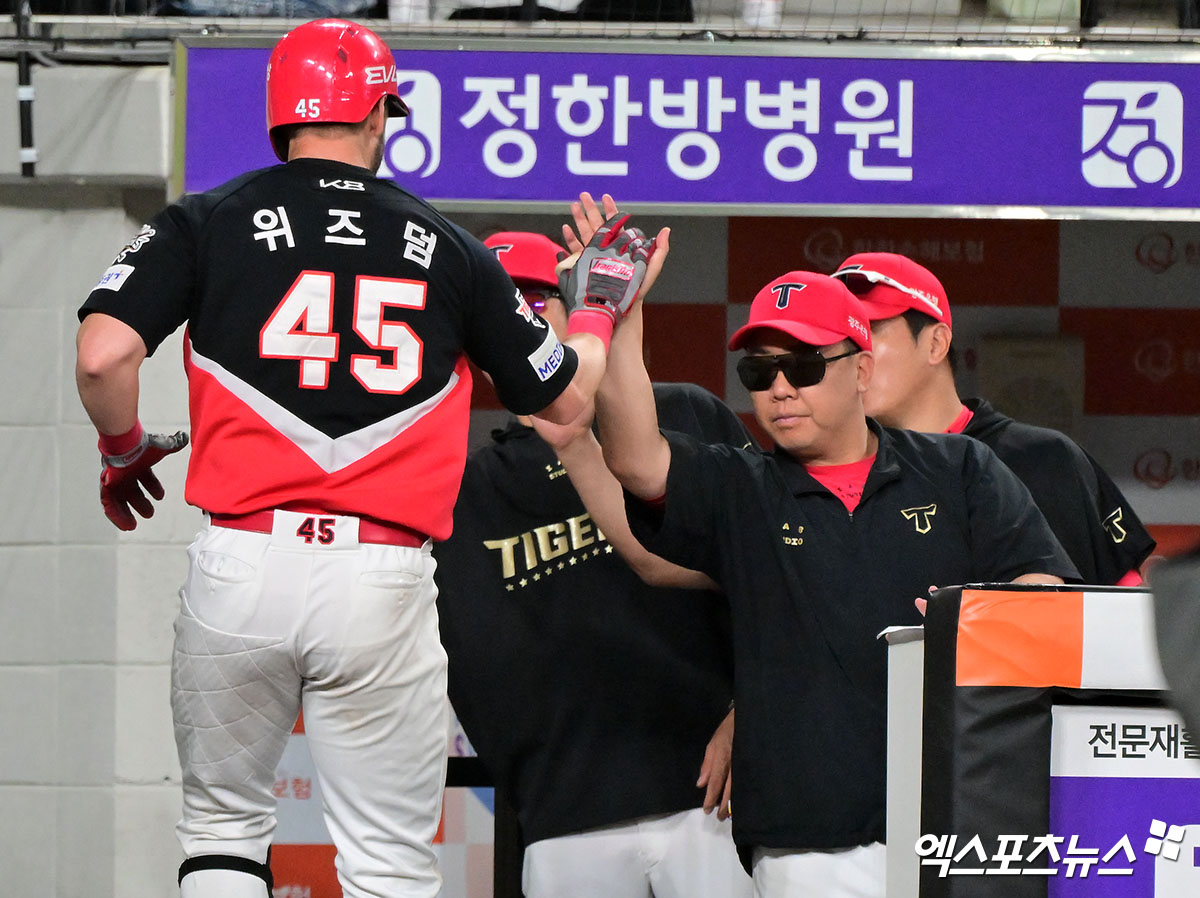 KIA 타이거즈 패트릭 위즈덤이 정규시즌 경기에서 홈런을 친 뒤 이범호 감독과 하이파이브하고 있다. 엑스포츠뉴스 DB