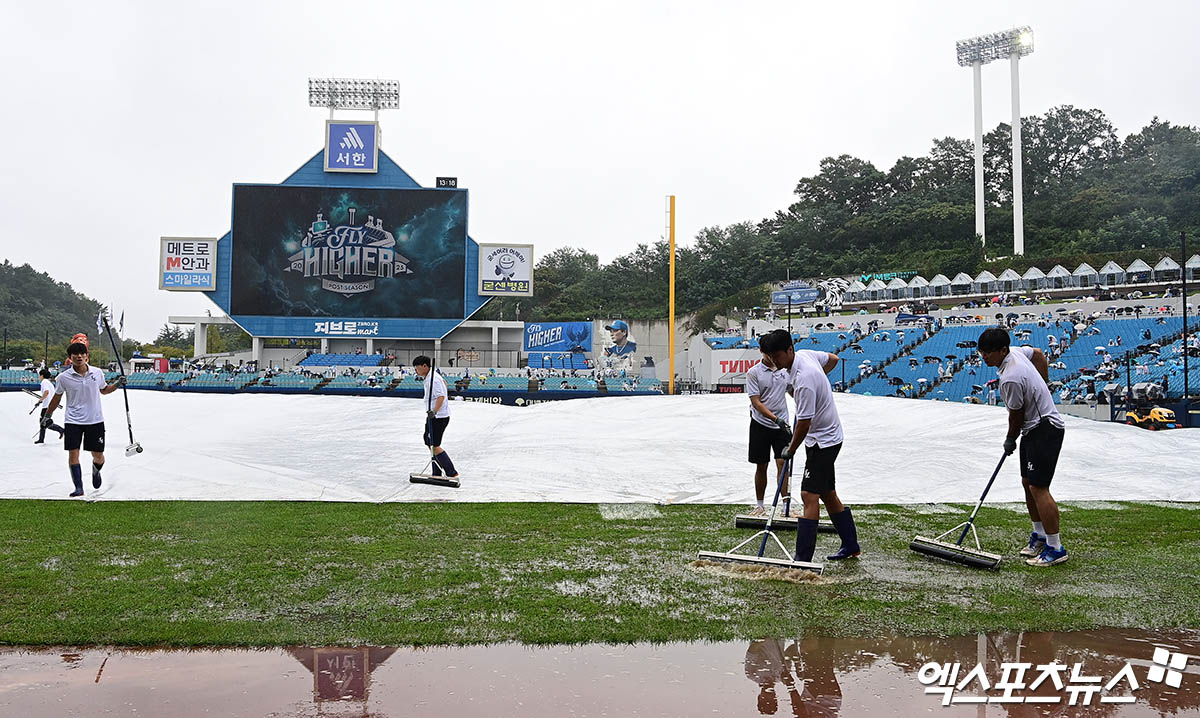 6일 오후 대구삼성라이온즈파크에서 열리는 '2025 신한 SOL Bank KBO 포스트시즌' NC 다이노스와 삼성 라이온즈의 와일드카드 1차전 경기에 앞서 구장 관리 요원들이 방수포의 물을 걷어내는 작업을 하고 있다. 대구, 박지영 기자