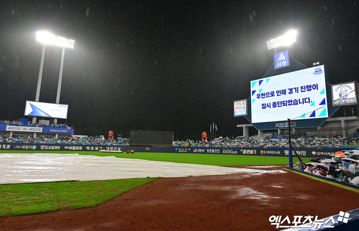 13일 오후 대구삼성라이온즈파크에서 열린 '2025 신한 SOL Bank KBO 포스트시즌' SSG 랜더스와 삼성 라이온즈의 준플레이오프 3차전 경기, 1회말 삼성 김지찬 타석때 갑작스럽게 내린 폭우로 경기가 중단되었다.  그라운드에 방수포가 덮여져있다. 대구, 김한준 기자