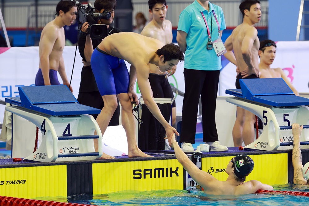 19일 부산 아시아드주경기장에서 열린 제106회 전국체육대회 수영 남자 계영 800m에서 황선우(강원도청)가 1위로 레이스를 마친 뒤 김우민(강원도청)과 손을 맞대고 있다. 사진 연합뉴스