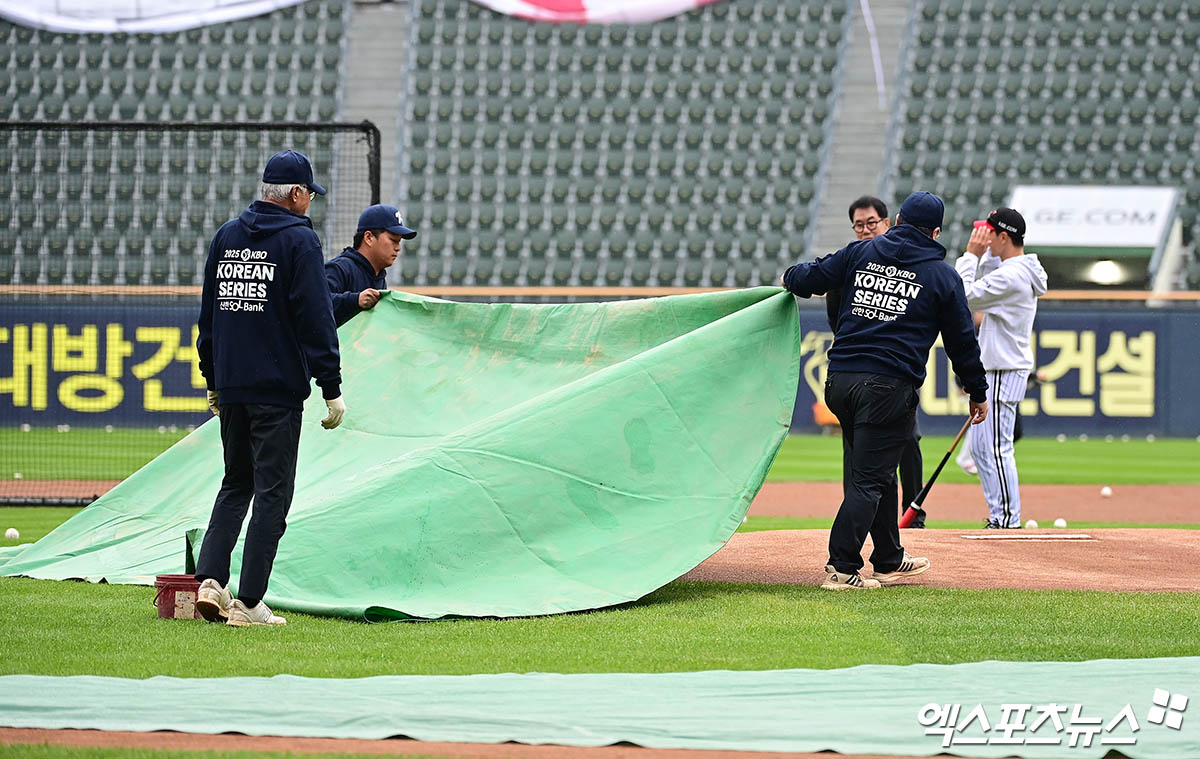 26일 오후 서울 송파구 잠실야구장에서 열리는 '2025 신한 SOL Bank KBO 한국시리즈' 한화 이글스와 LG 트윈스의 1차전 경기에 앞서 그라운드 정비 직원들이 마운드에 방수포를 덮고 있다. 잠실, 박지영 기자