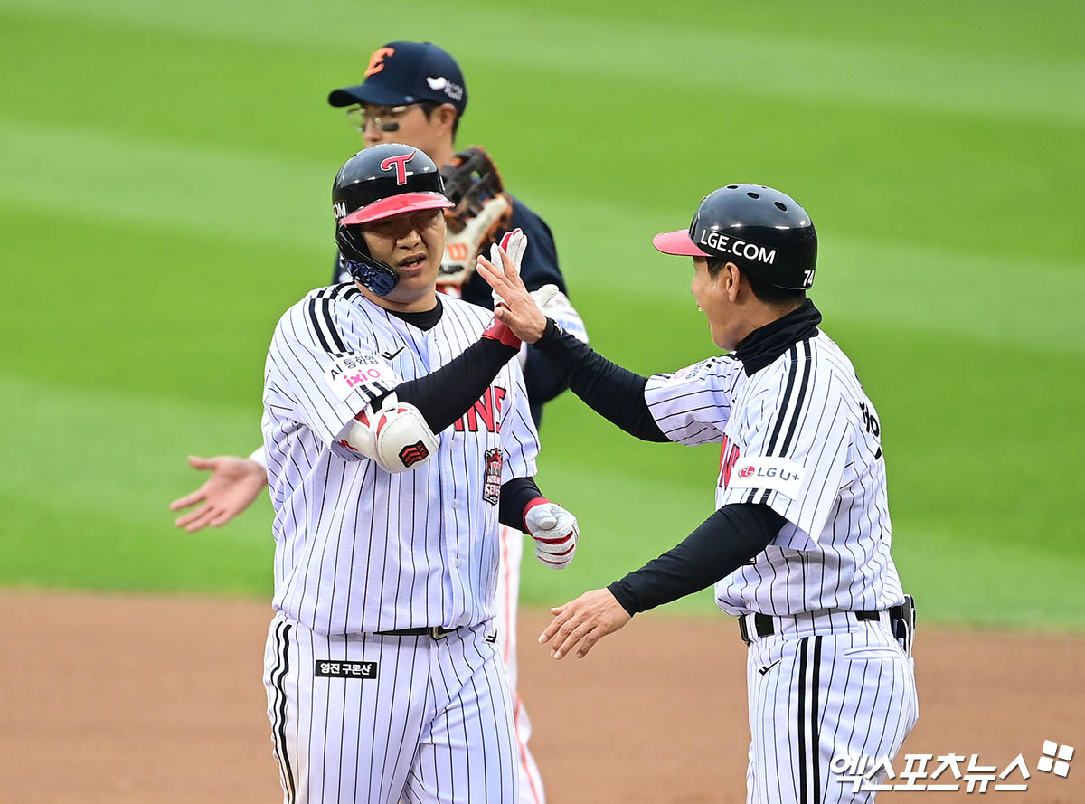 26일 오후 서울 송파구 잠실야구장에서 열린 '2025 신한 SOL Bank KBO 한국시리즈' 한화 이글스와 LG 트윈스의 1차전 경기, 6회말 2사 1,2루 LG 문보경이 적시타를 때려낸 뒤 1루에서 송지만 주루코치와 하이파이브를 나누고 있다. 잠실, 박지영 기자