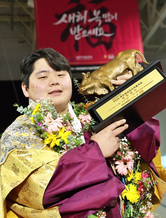 18일(수) 충청남도 태안군 태안종합실내체육관에서 열린 ‘위더스제약 2026 태안설날장사씨름대회’ 백두장사(140kg이하)에 등극한 김민재(영암군민속씨름단)가 황소트로피를 들고 기념사진을 찍고 있다.