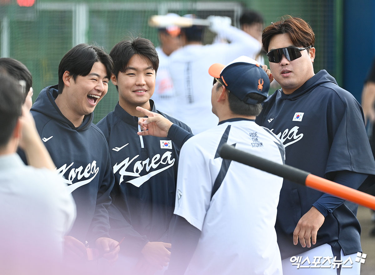 2026 월드베이스볼클래식(WBC)에 출전하는 류현진(오른쪽 첫 번째)이 21일 일본 오키나와 고친다 구장에서 열리는 소속팀 한화 이글스와의 연습경기 선발등판을 앞두고 정우주(가운데), 노시환과 함께 대화하는 모습. 사진 고아라 기자