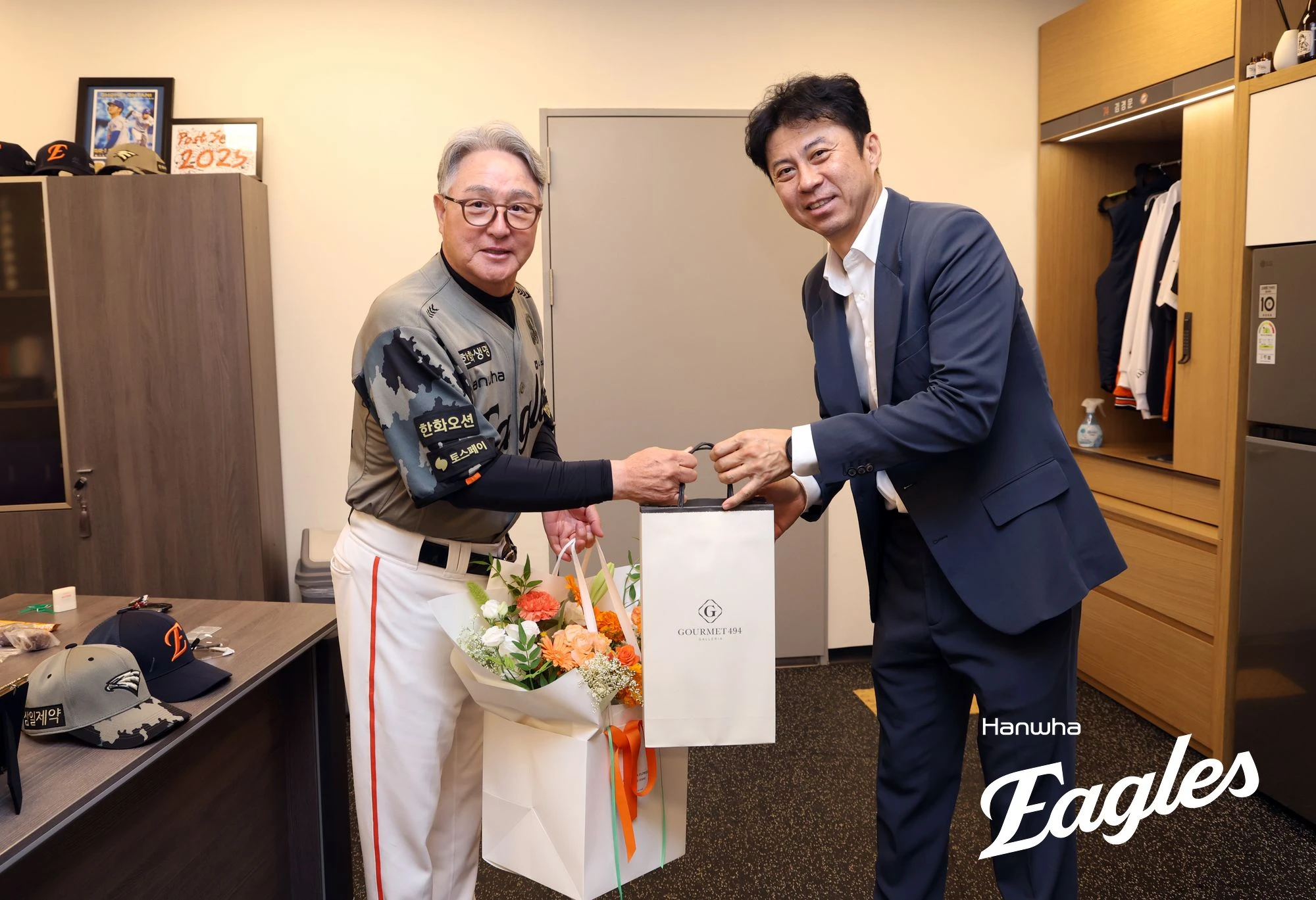김경문(왼쪽) 한화 이글스 감독이 20일 대전 한화생명 볼파크에서 열린 2026 신한 SOL KBO리그 삼성 라이온즈와의 팀 간 8차전에 앞서 손혁 한화 단장에게 KBO 역대 네 번째 감독 2000경기 출장 기념 꽃다발과 선물을 받는 모습. 사진 한화 이글스
