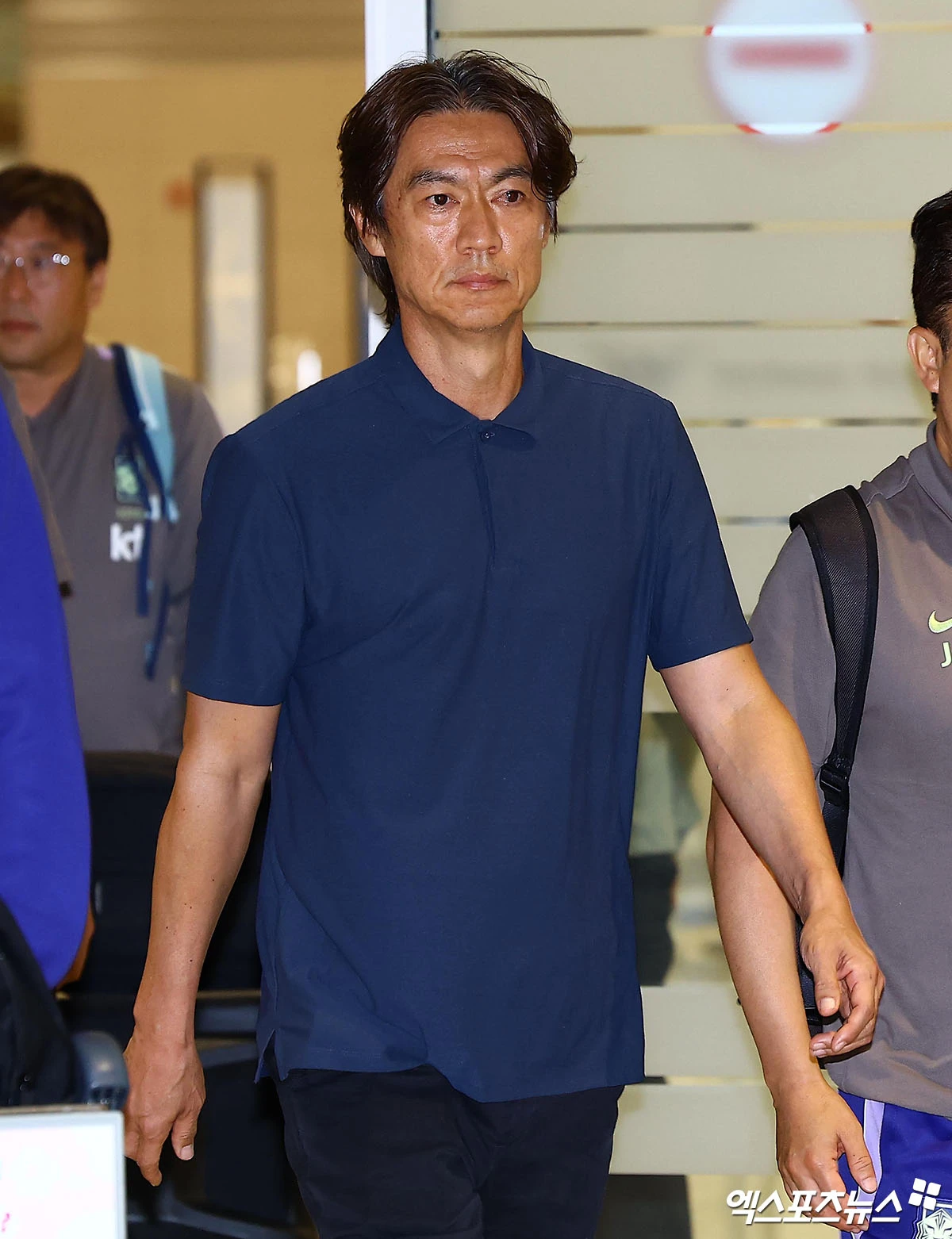 2026 월드컵에서 조별리그 탈락하며 32강에도 오르지 못하고 한국 축구사 최악의 월드컵 결과를 낳은 축구 국가대표팀의 홍명보 감독이 귀국했다. 홍 감독이 대표팀을 처음 맡았던 12년 전 2014 브라질 월드컵 참패 직후처럼 엿이 날아들진 않았으나 홍 감독 향한 고성과 비난의 현수막이 등장하는 등 험악한 분위기가 연출됐다. 홍 감독은 조현우(울산), 김민재(뮌헨), 황인범(페예노르트), 황희찬(울버햄프턴), 백승호(버밍엄시티), 김문환(대전), 이강인(파리 생제르맹), 설영우(즈베즈다)와 함께 30일 새벽 인천국제공항을 통해 입국했다. 홍 감독이 귀국하자 '홍명보 나가', '연봉 반납하라'를 비롯한 고성과 욕설, 북소리가 오가며 줄곧 소란스러웠다. 비행기 도착 소식이 알려진 뒤 기다림이 길어지자 '왜 나오지 않느냐'는 볼멘소리도 곳곳에서 들리기도 했다. 인천공항, 김한준 기자