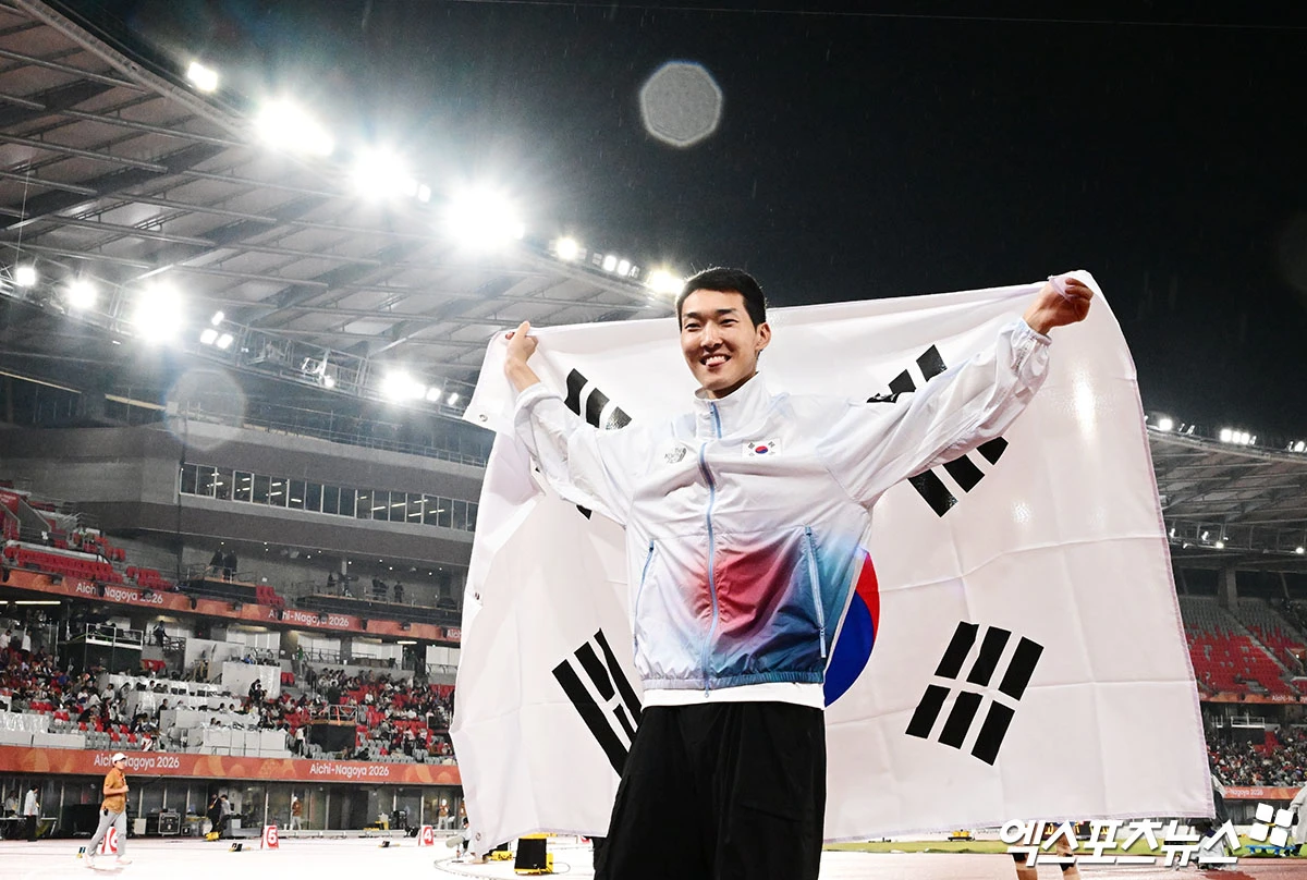 27일 일본 나고야 미즈호공원 육상경기장에서 열린 '2026 아이치·나고야 아시안게임' 남자 높이뛰기 결선에 출전한 대한민국 우상혁이 2m22를 기록하며 전체 14명 중 최종 3위로 동메달을 획득했다. 경기 종료 후 우상혁이 태극기를 들고 환히 웃고 있다. 일본 나고야, 박지영 기자